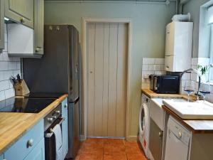 a kitchen with a refrigerator and a washing machine at Owl Cottage in Fordwich