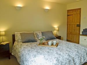 a bedroom with a bed with a tray with flowers on it at Owl Cottage in Fordwich