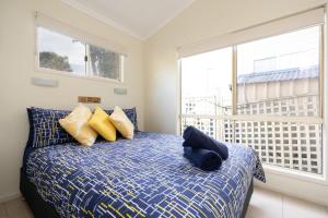 a bedroom with a bed with blue and yellow pillows at Tasman Holiday Parks - Myola in Myola
