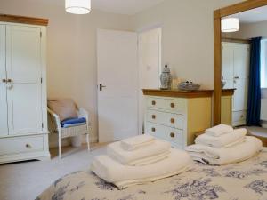 a bedroom with a bed with four pillows on it at Maple Lodge in Corsham
