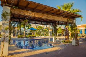 a pavilion with a swimming pool in a resort at Planta Baja, a 10 minutos de la playa, Gran alberca y Mini Golf!! in Mazatlán