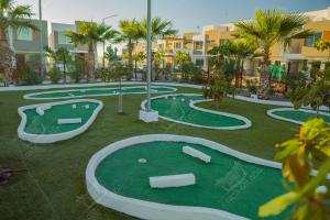 a golf course in a resort with palm trees and buildings at Planta Baja, a 10 minutos de la playa, Gran alberca y Mini Golf!! in Mazatlán