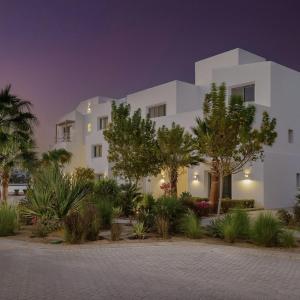 a white building with trees in front of it at EL Gouna Swan Lake Apartment in Hurghada