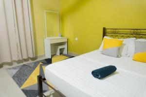 a bedroom with a large white bed with yellow walls at 5 Bedrooms Homestay with Private Pool (SEROJA) in Nilai