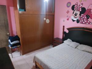 a bedroom with a bed with a mickey mouse sticker on the wall at Amplia y Hogareña Casa in Aguascalientes