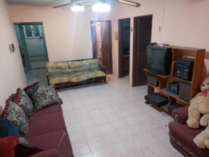 a living room with a couch and a tv at Amplia y Hogareña Casa in Aguascalientes
