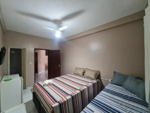 - une chambre avec un lit et un ventilateur de plafond dans l'établissement Pousada Meireles Praia, à Fortaleza