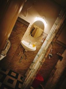 ein Badezimmer mit einem Waschbecken und einem großen Spiegel in der Unterkunft OH Kolkata - Sutanuti Homestay in Kalkutta