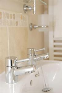 a bathroom with a sink with two faucets at The Carlton in Rugby