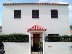 Biały dom z czerwonym dachem w obiekcie Costa da Caparica Beach House w Costa de Caparica