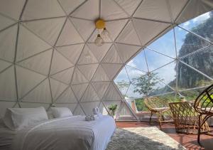 カオソックにあるCosy Garden Khao Sokのベッドと椅子付きの大きなテントが備わる客室です。