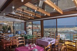 バトゥルーンにあるL'Auberge de la Merのテーブルと椅子と窓のあるダイニングルーム