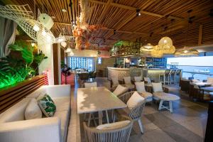 un restaurante con mesas y sillas y un bar en Saigon Quy Nhon Hotel, en Quy Nhon