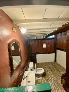 a bathroom with a toilet and a sink and a mirror at Baanphuthadol in Mae Hong Son