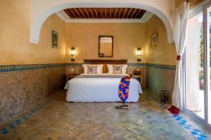 a bedroom with a bed and a large window at Double room in a charming villa in the heart of Marrakech palm grove in Marrakesh