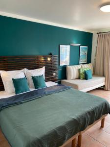 a bedroom with a large bed and a couch at Studio Tropical avec vue mer dans une résidence hôtelière in Sainte-Luce