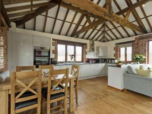 a kitchen with a table and chairs and a couch at Elm Tree Barn in Felmingham