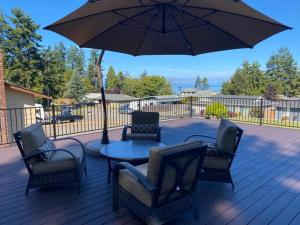 a patio with a table and chairs and an umbrella at PA Sea View Deck House in Port Angeles