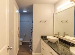 een badkamer met een wastafel, een toilet en een spiegel bij PA Sea View Deck House in Port Angeles