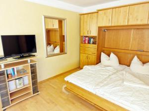 Schlafzimmer mit einem Bett und einem Flachbild-TV in der Unterkunft Strandhotel S33-103 in Heiligenhafen