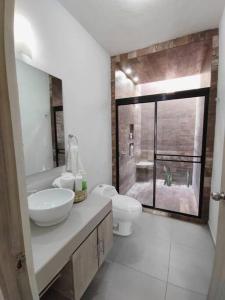łazienka z umywalką, toaletą i oknem w obiekcie ESTANCIA LA CARRETA w mieście Matehuala