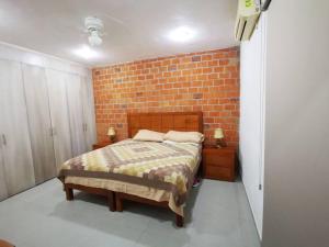 sypialnia z łóżkiem i ceglaną ścianą w obiekcie ESTANCIA LA CARRETA w mieście Matehuala