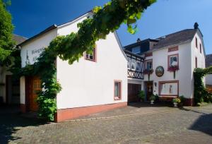 ein weißes Gebäude mit Efeu an der Fassade in der Unterkunft Gästehaus Alfons und Marianne Eifel in Trittenheim