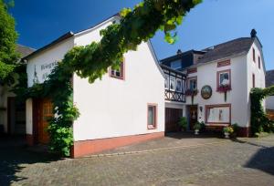 a white building with ivy on the facade at Gästehaus Alfons und Maria Anna Eifel in Trittenheim