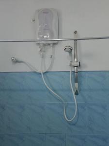 a shower with a hose attached to a wall at D.K. Rest inn in Embilipitiya