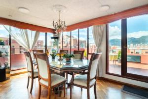 comedor con mesa y sillas y ventana grande en Habitaciones en un alojamiento -Anfitrion - Elias Di Caprio en Bogotá