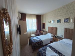 イスタンブールにあるHamit Hotelのベッド2台と鏡が備わるホテルルームです。