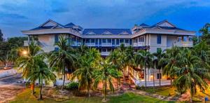 a large house with palm trees in front of it at Long Sands Port Dickson in Port Dickson