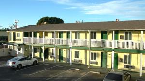 a car parked in a parking lot in front of a building at City Center Motel - Oxnard in Oxnard