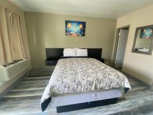 a bedroom with a bed and a painting on the wall at City Center Motel in Oxnard