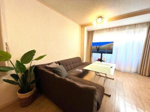 sala de estar con sofá y mesa en Nao's Guesthouse 2 一軒家貸切 en Osaka