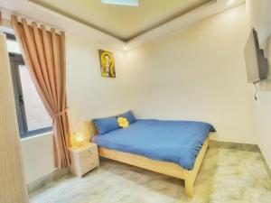 - une petite chambre avec un lit bleu et une fenêtre dans l'établissement Vĩnh Hà Motel, à Trai Mat