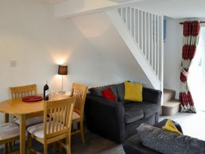 a living room with a couch and a table at Pottergate Cottage in Wroxham