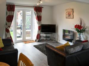 a living room with a couch and a television at Pottergate Cottage in Wroxham