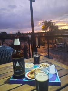 una botella de cerveza y un plato de comida en una mesa en CALUANABRU en Malargüe