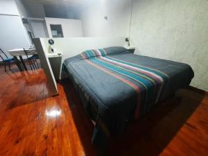 Cama pequeña en habitación con mesa en CALUANABRU en Malargüe