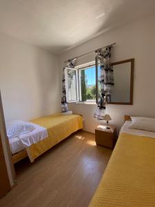 Habitación con 2 camas y ventana en Apartments Jak - comfortable apartments, en Mirce