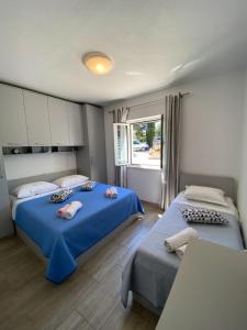 1 dormitorio con 2 camas y ventana en Apartments Jak - comfortable apartments, en Mirce