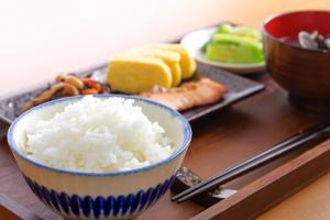 a table with a bowl of rice and a plate of food at Hotel Kaguya in Himeji