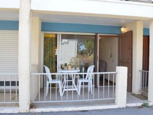 un porche cubierto con mesa y sillas en Appartement Fleury-Saint-Pierre-la-Mer, 1 pièce, 2 personnes - FR-1-229D-232, en Saint Pierre La Mer