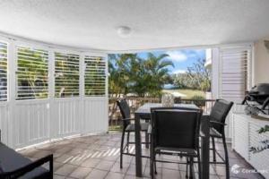 a dining room with a table and chairs on a patio at Kawana Waters Ocean Front Unit- Sunshine Coast in Buddina