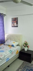 Un dormitorio con una cama y una mesa con una planta en Homestay Putrajaya , Icha Homestay Presint 9 en Putrajaya