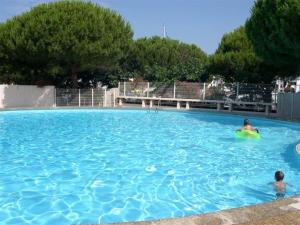 zwei Personen in einem großen Pool mit Frisbee in der Unterkunft Appartement Port Camargue, 1 pièce, 4 personnes - FR-1-250-196 in Le Grau-du-Roi