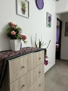 a dresser with flowers on top of it in a room at Homestay Putrajaya , Icha Homestay Presint 9 in Putrajaya