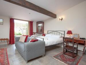 a bedroom with a bed and a couch and a desk at The Old Forge in Bleadon