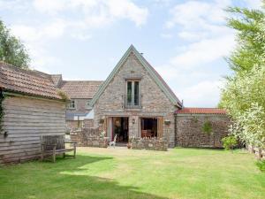 an external view of a stone house with a yard at The Old Forge in Bleadon